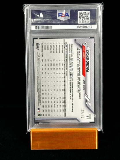 A graded 2024 Topps trading card featuring Shohei Ohtani numbered 29/75, sealed in a clear PSA graded case and displayed on an orange wooden stand against a black background.