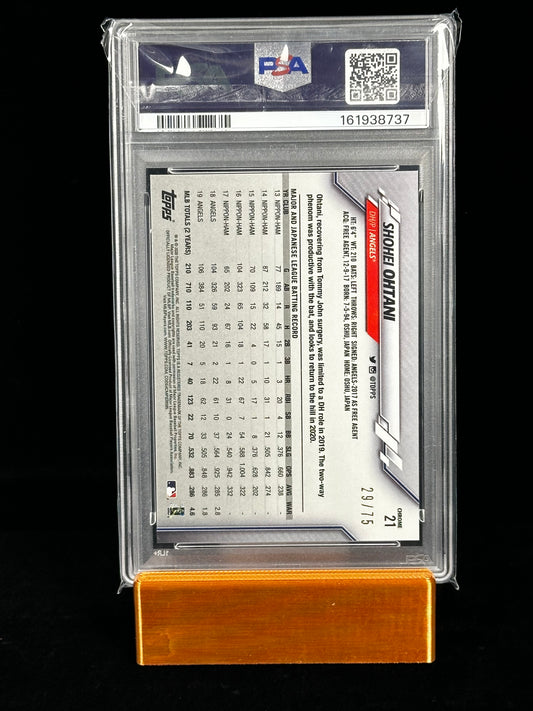 A graded 2024 Topps trading card featuring Shohei Ohtani numbered 29/75, sealed in a clear PSA graded case and displayed on an orange wooden stand against a black background.