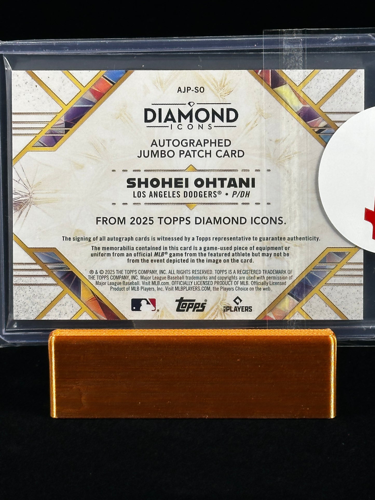 A Topps Diamond Icons autographed jumbo patch card featuring Shohei Ohtani, displayed in a clear protective case with a gold-colored metal stand against a black background.