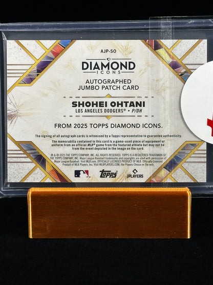 A Topps Diamond Icons autographed jumbo patch card featuring Shohei Ohtani, displayed in a clear protective case with a gold-colored metal stand against a black background.