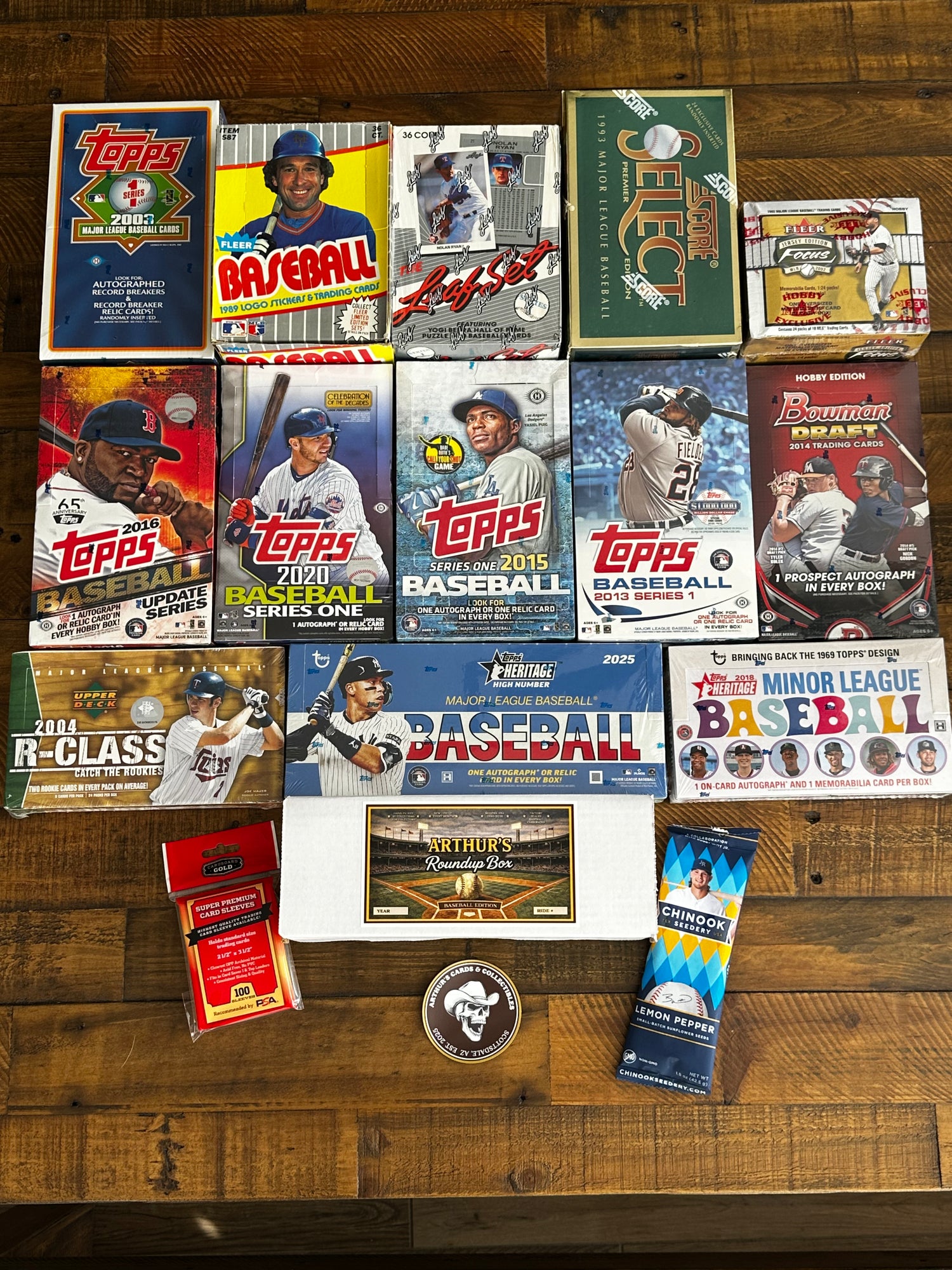 Collection of Topps baseball trading card packs and related items on a wooden surface