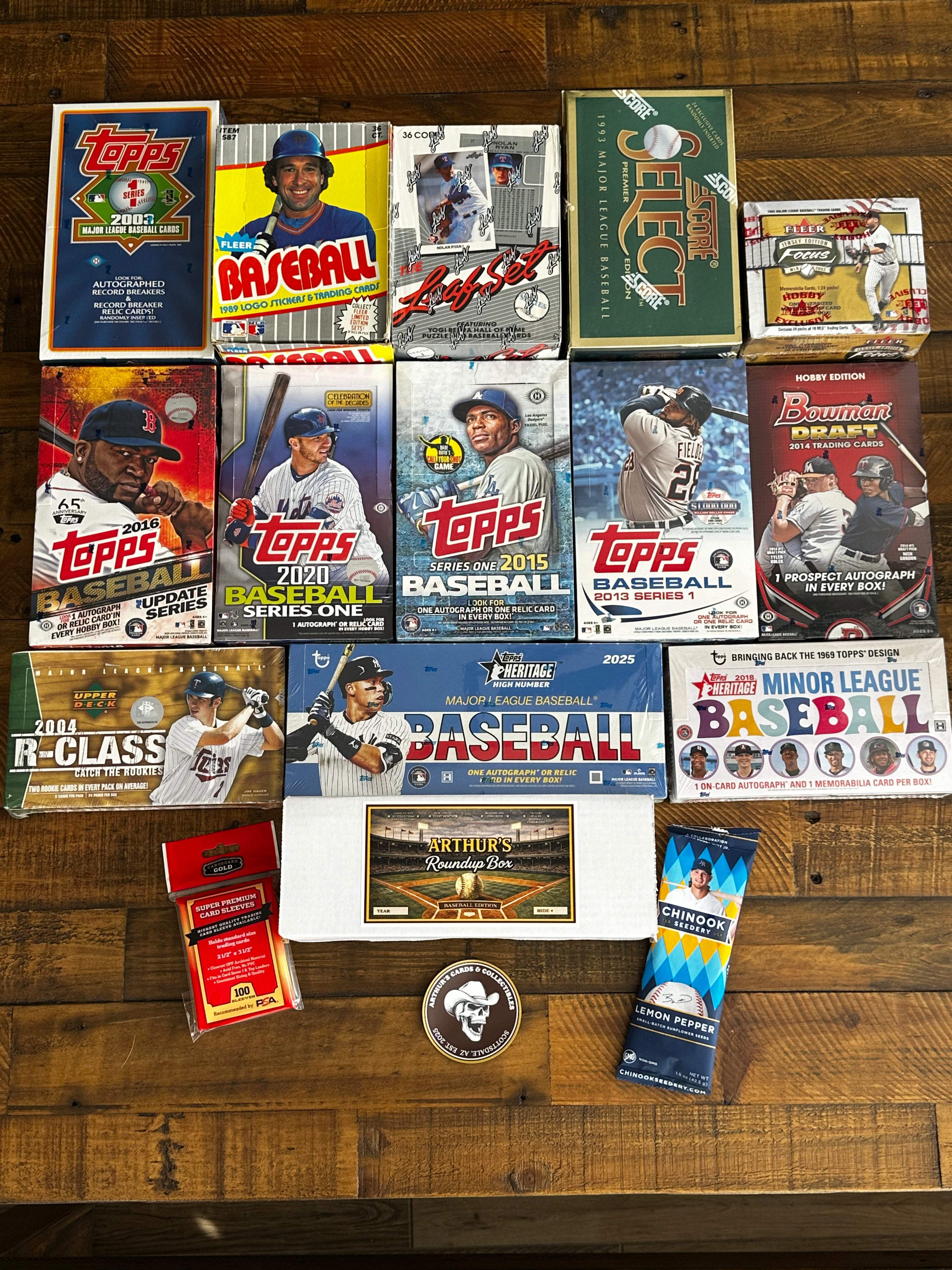 Collection of Topps baseball trading card packs and related items on a wooden surface