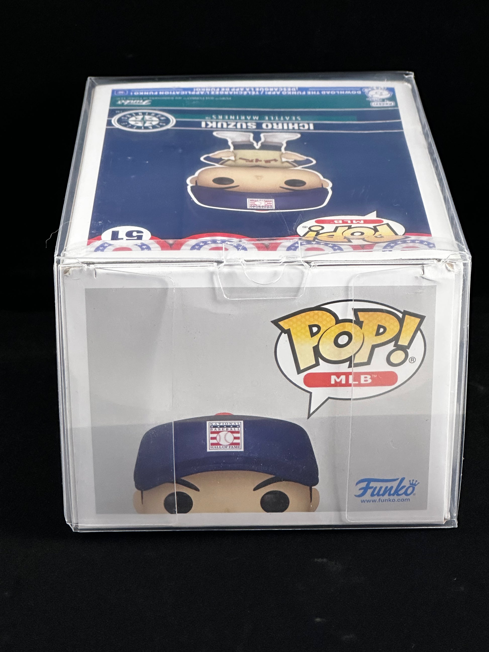 A Funko Pop! MLB baseball figure in a clear plastic protective case, featuring Ichiro Suzuki. The figure is wearing a navy blue baseball cap and has a tan face, set against a black background.