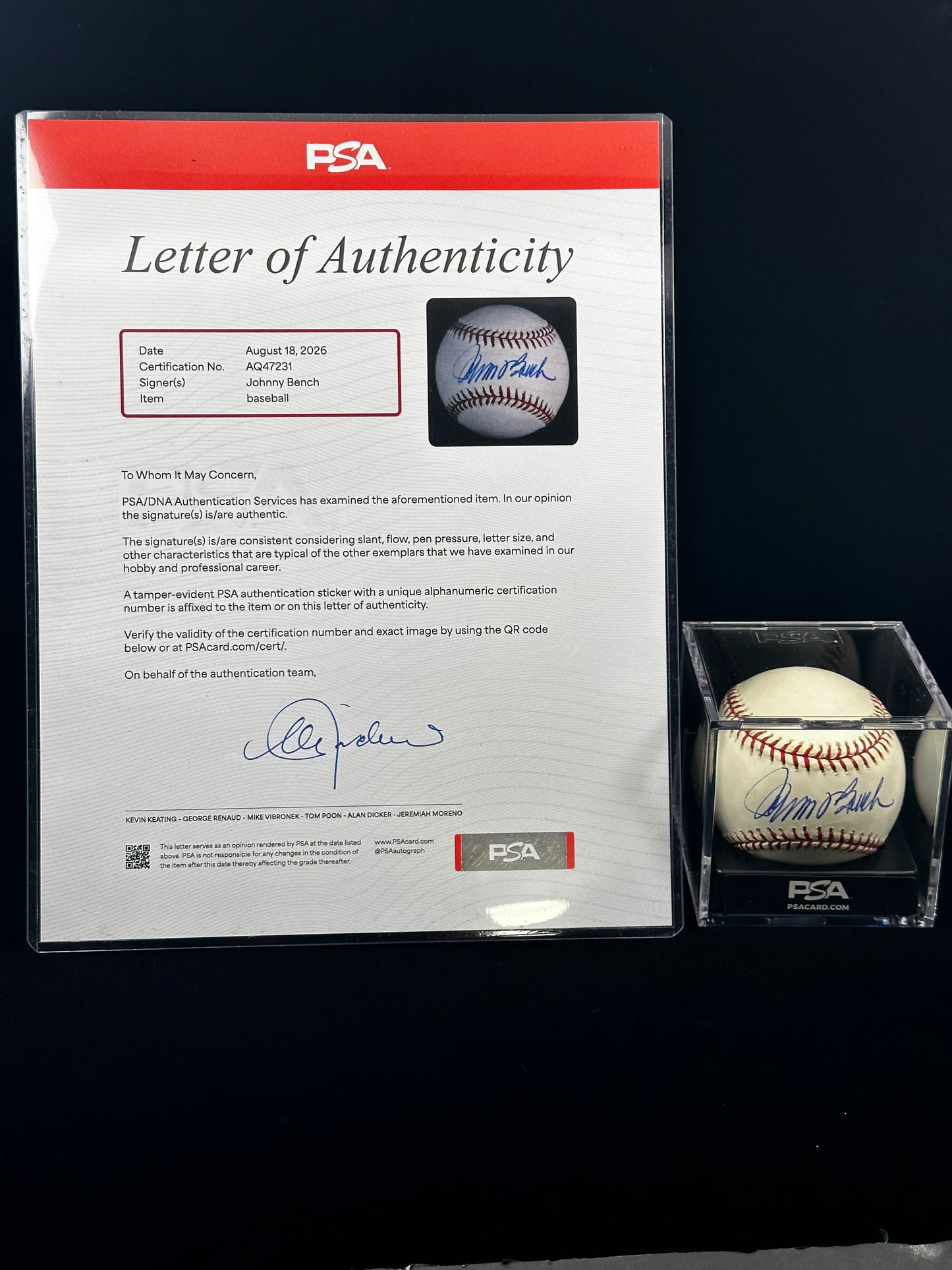 A PSA-authenticated baseball displayed in a clear acrylic case next to its Letter of Authenticity card, photographed against a dark background.