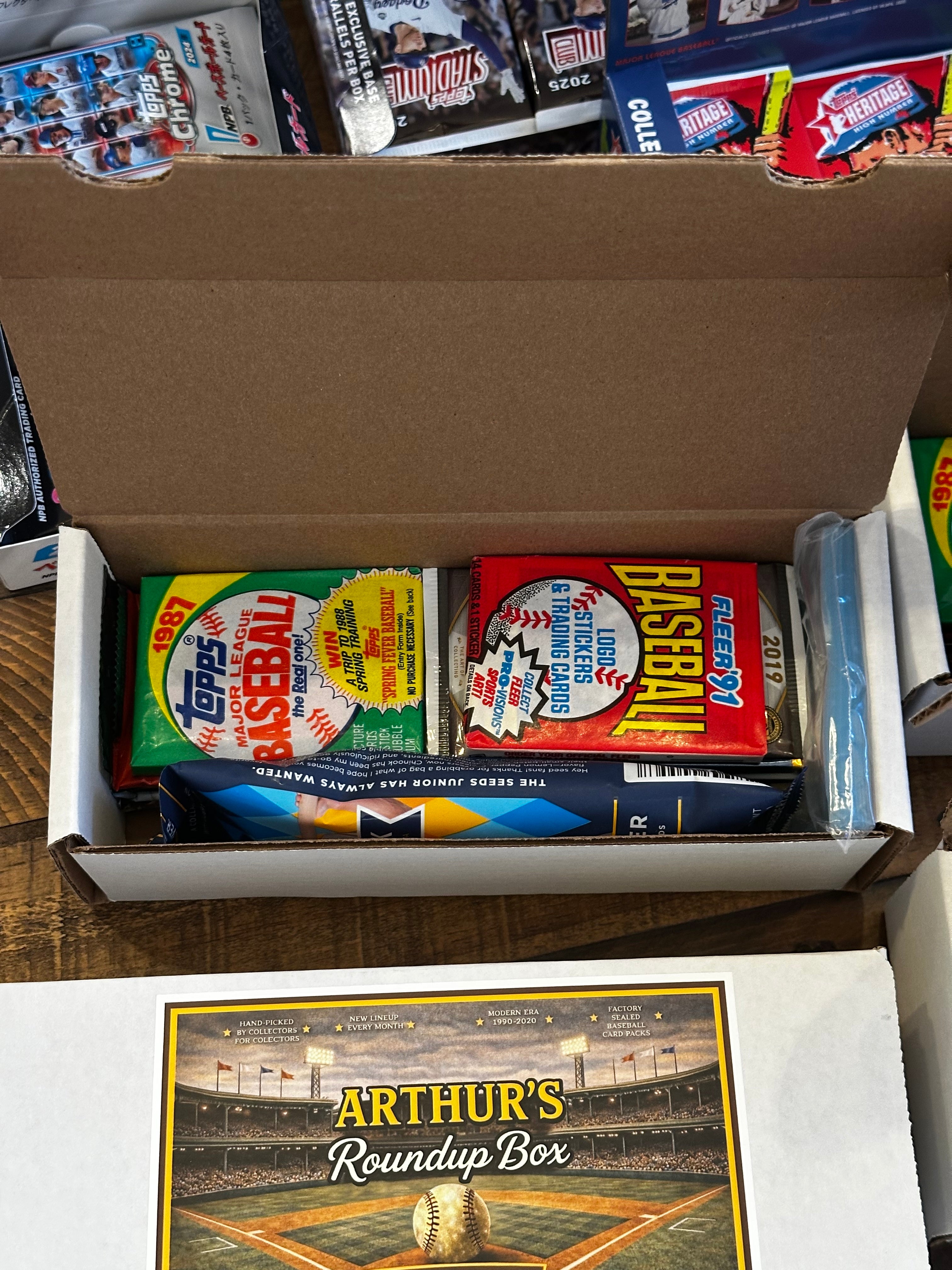 Collection of baseball trading card boxes in a box with 'Arthur's Roundup Box' visible.