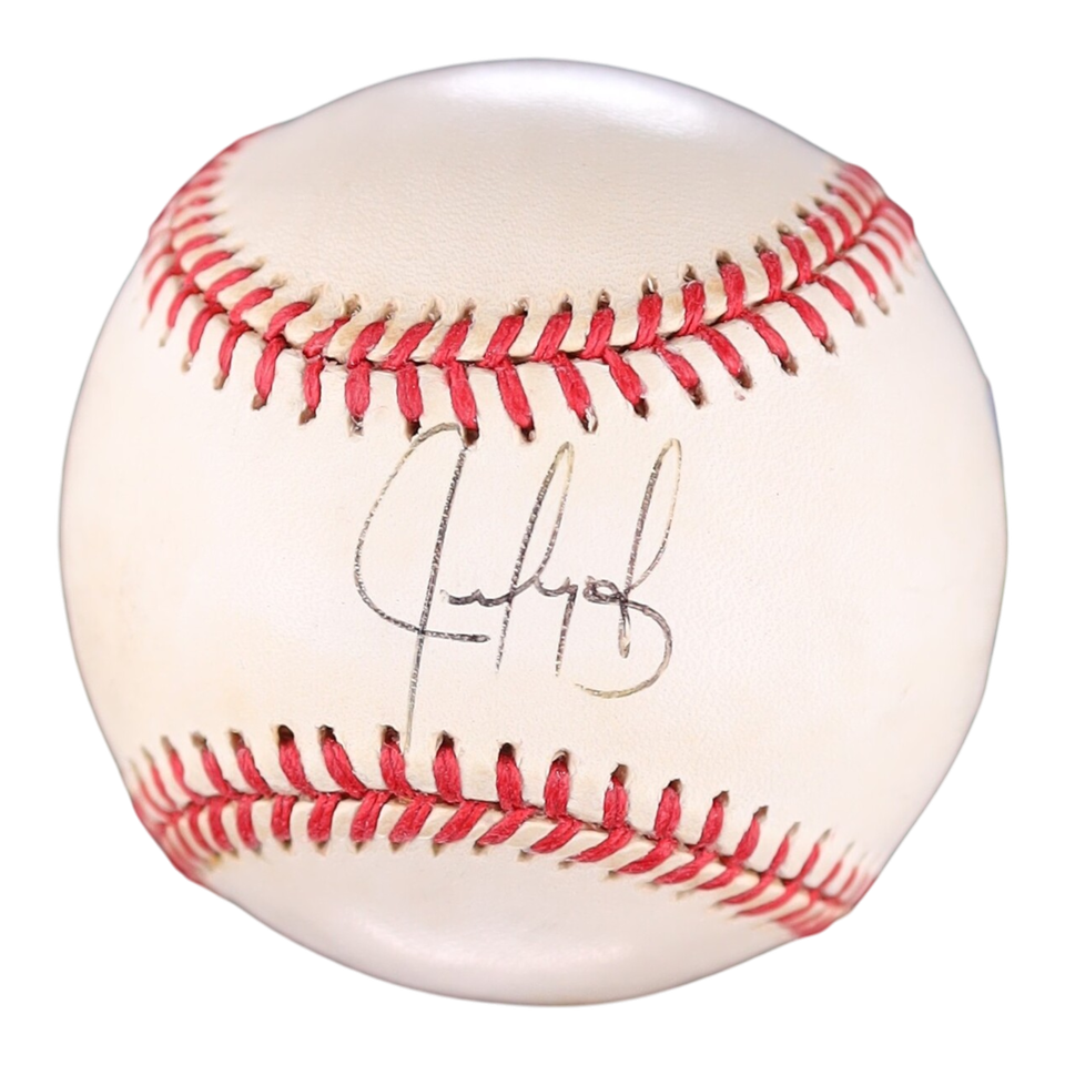 An autographed baseball with Juan Gonzalez black ink signature on the front, featuring classic red stitching on a white leather surface.
