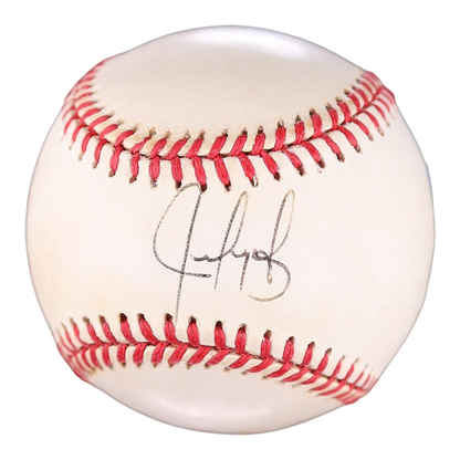 An autographed baseball with Juan Gonzalez black ink signature on the front, featuring classic red stitching on a white leather surface.