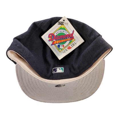 A vintage baseball cap by New Era, featuring a dark navy blue crown with a beige underside and a matching beige visor. The cap has an attached 'Authentic Diamond Collection' hangtag and a small MLB logo on the front.