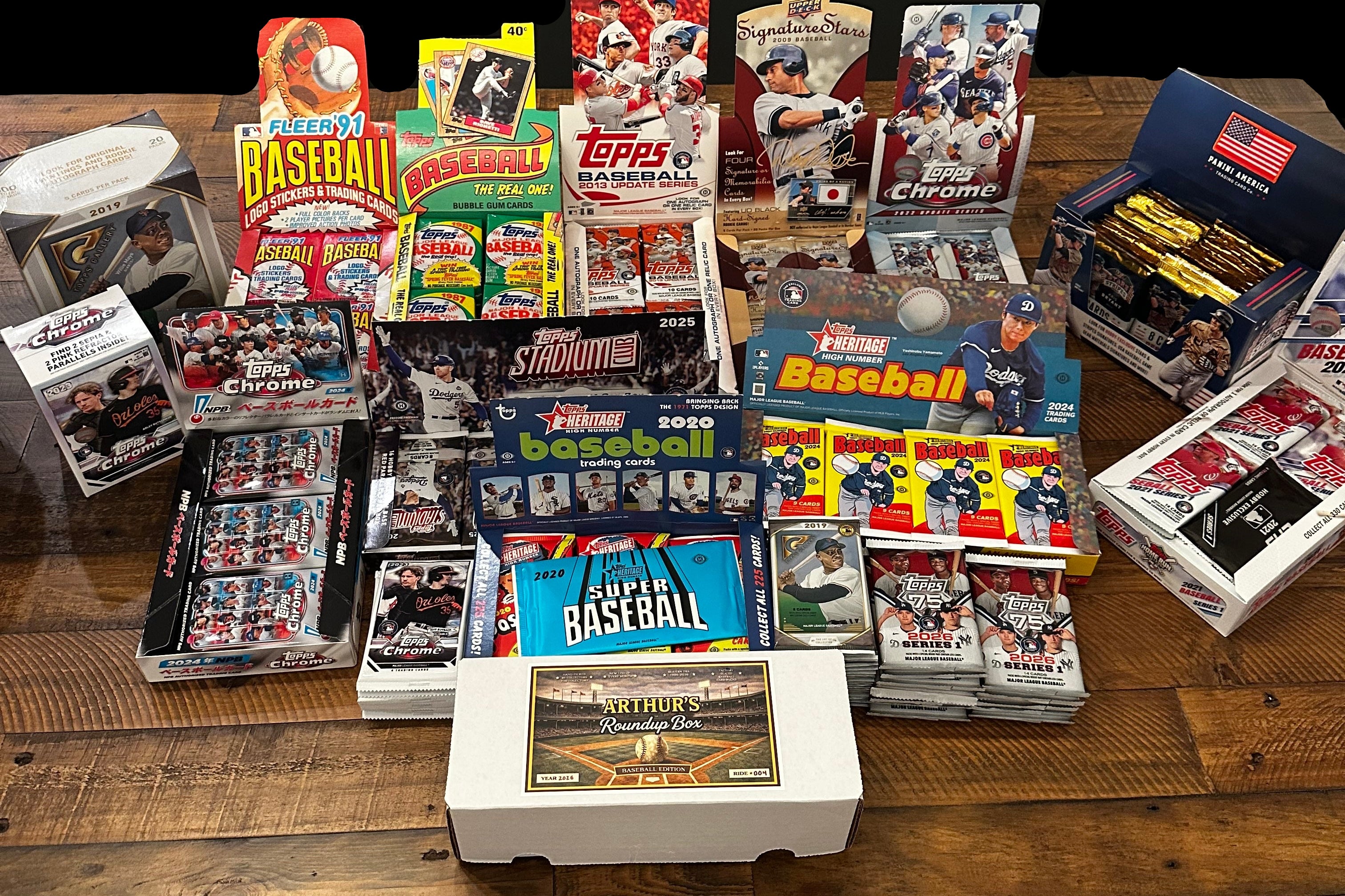 Collection of baseball trading cards and packaging on a wooden table.