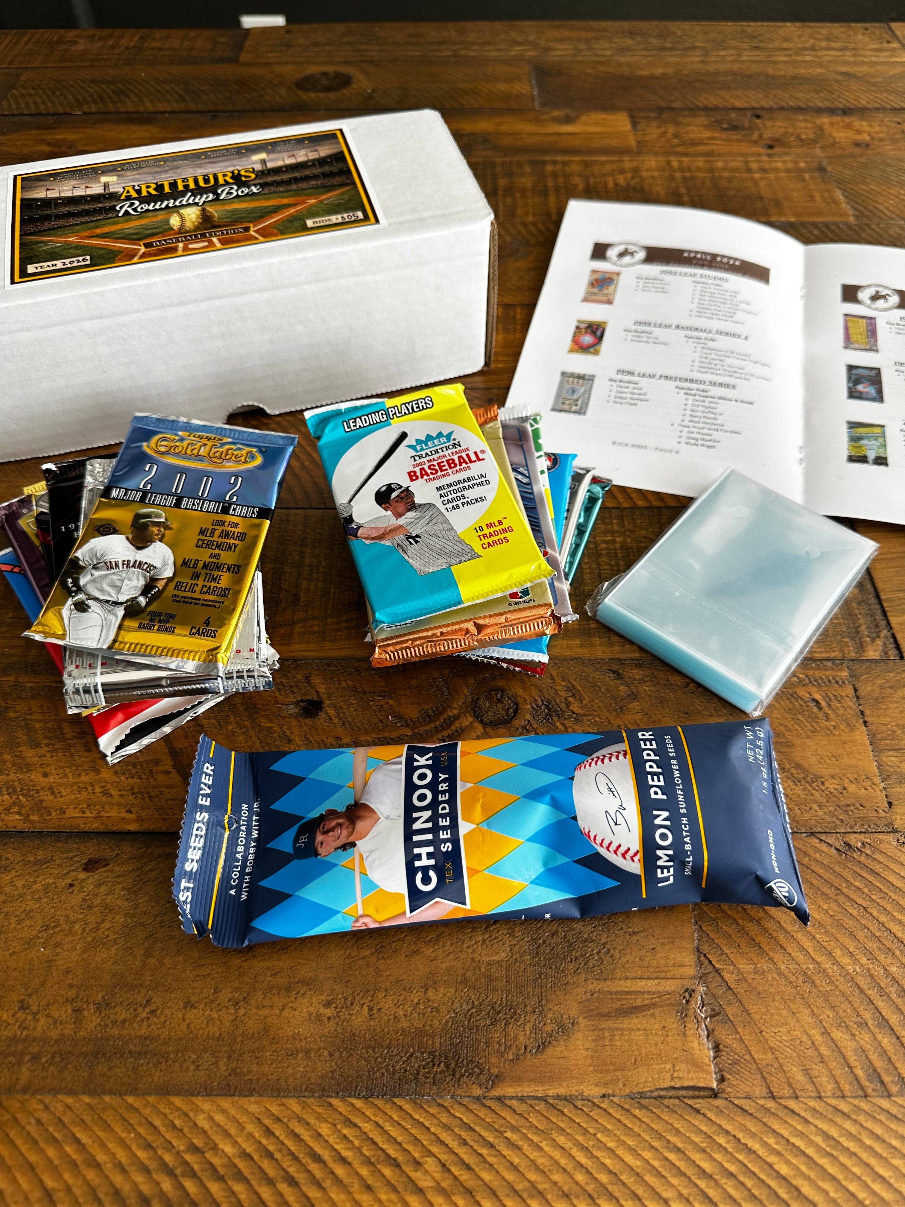 Collection of baseball cards and a Chinook Lemon Pepper package on a wooden surface