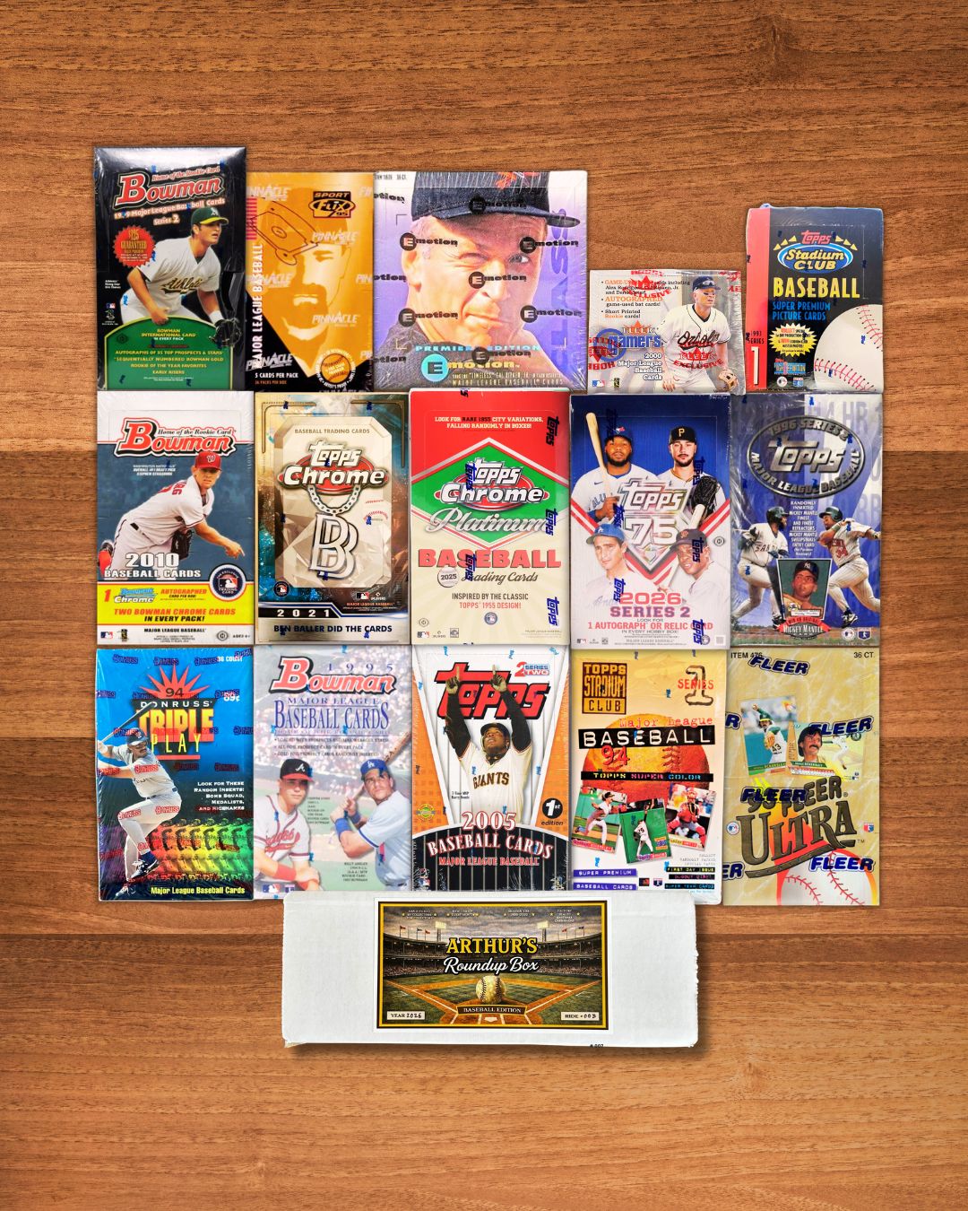 A collection of vintage and modern baseball trading card packs and a white 1994 Topps Rookie Card laid out on a wooden surface.