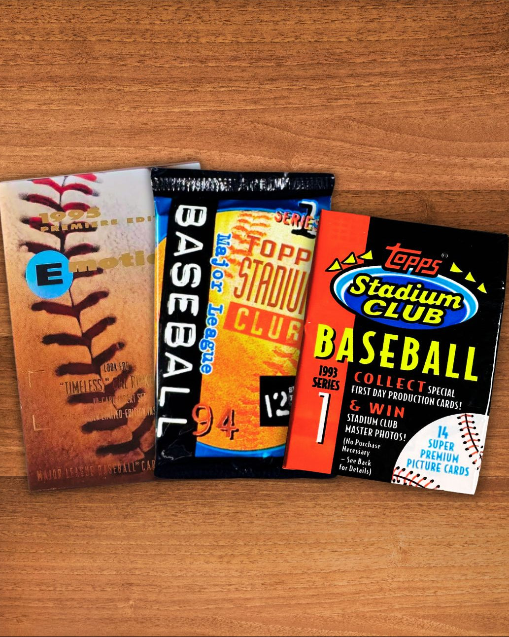 Three vintage baseball trading card packs arranged on a wooden tabletop: a Topps Stadium Club pack on the right, a Toppo Straw Club pack in the middle, and an older baseball card pack on the left.